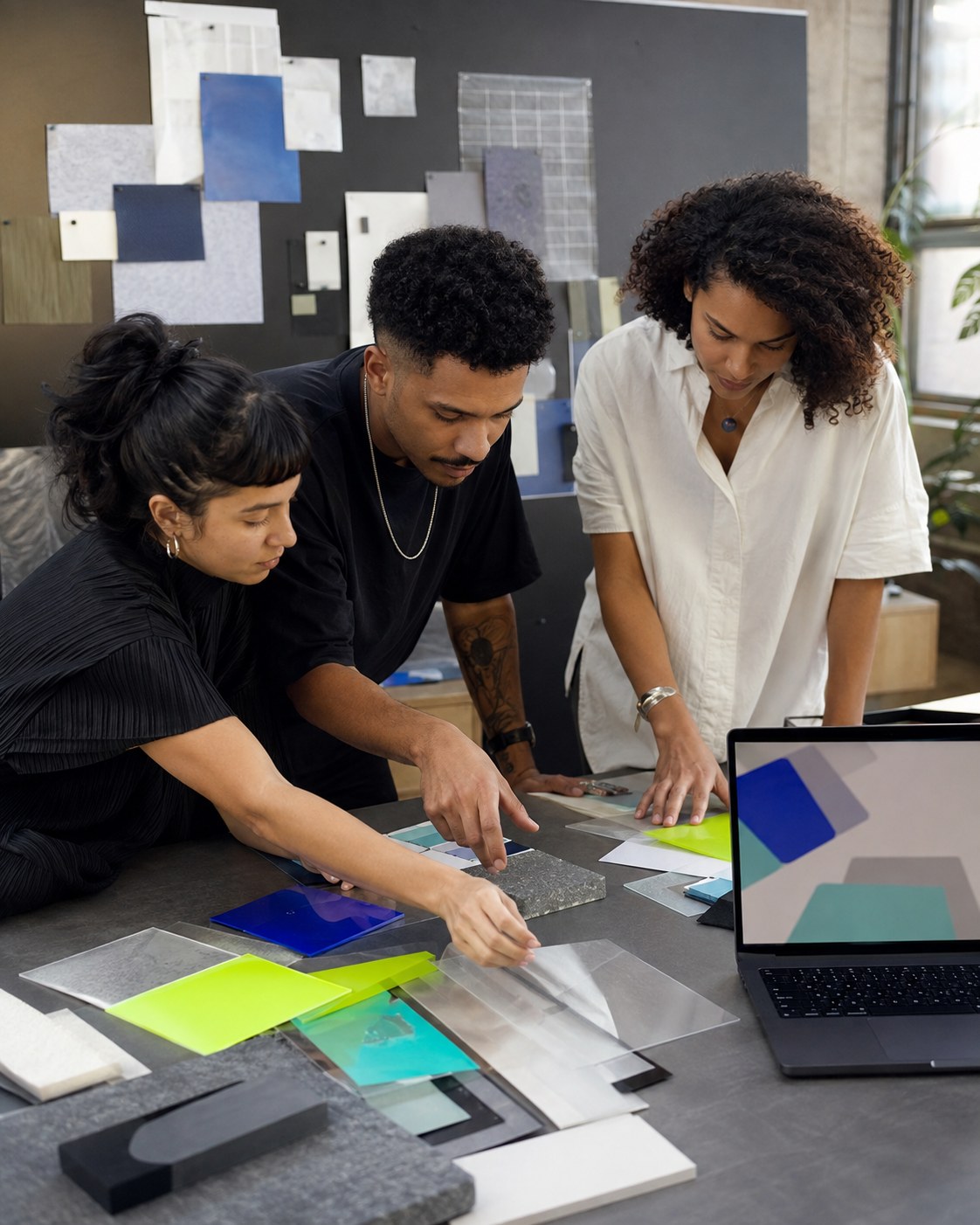 Profissionais colaborando em torno de materiais e uma interface digital
